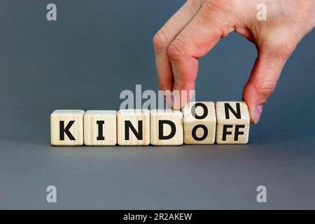 Kind on or off symbol. Businessman turns wooden cubes and changes word Kind off to Kind on. Beautiful grey table grey background. Business and kind on Stock Photo