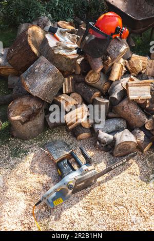 Chopped logs with chainsaw and salty helmet Stock Photo