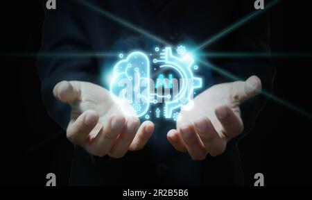A businessman has a virtual graphic of Artificial Intelligence in his hand. Chatbot, Chat with AI, Futuristic technology transformation. Ai technology Stock Photo