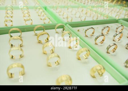 Gold jewelry engagement rings, gold diamond rings show in retail store window display showcase. Jewelery showcase concept photo idea. Selective focus. Stock Photo