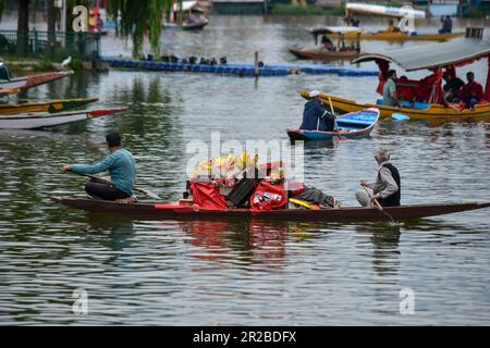 Srinagar, India. 18th May, 2023. Kashmiri men row their boat loaded with fruits during a cloudy weather in Srinagar, the summer capital of Jammu and Kashmir. (Photo by Saqib Majeed/SOPA Images/Sipa USA) Credit: Sipa USA/Alamy Live News Stock Photo