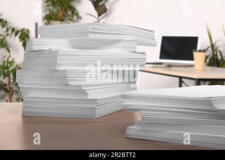 Stacked sheets of paper on wooden table in office Stock Photo