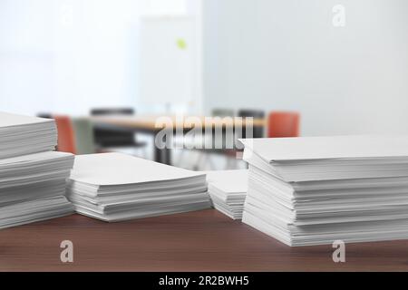 Stacked sheets of paper on wooden table in office, space for text Stock Photo
