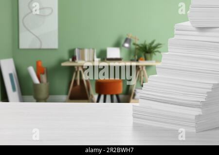 Stacked sheets of paper on white table in office, space for text Stock Photo