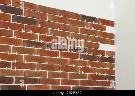 Decorative bricks with tile leveling system on white wall Stock Photo