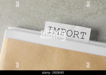 Note with word Import in documentation on light grey table, top view Stock Photo