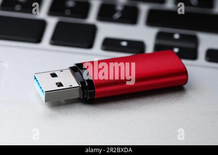 Modern usb flash drive on laptop, closeup Stock Photo