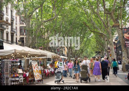 Hundreds of tourists strolling along La Rambla, surrounded by souvenir and food stalls.  Barcelona, Spain. Stock Photo