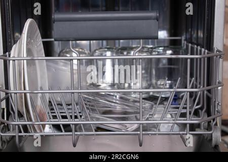 basket with clean dishes in the dishwasher in the kitchen, dishwasher with a plate Stock Photo