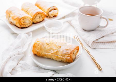Homemade apple strudel with cinnamon, apple pie with cup of fruit tea Stock Photo