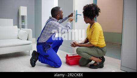 African Locksmith Man Changing And Fixing Door Lock Stock Photo