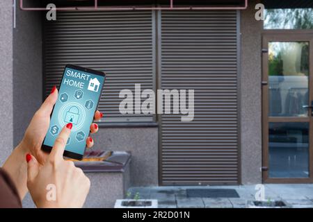 Cropped image of female entering secret key code for getting access and passing building using application on mobile phone, woman pressing buttons on Stock Photo
