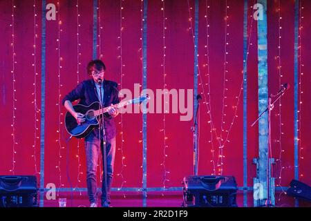 Solo artist Jack Songer performing at the the 2016 Stradisphere music festival in front of an impressive red stage set with fairy lights Stock Photo