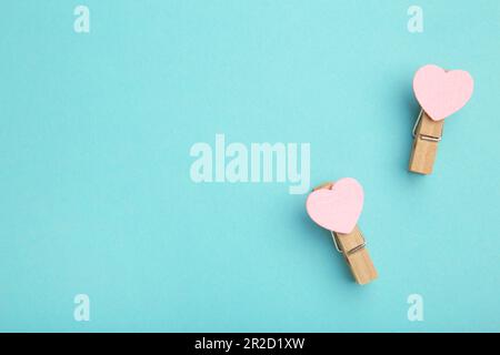 Two pink clothespins hearts on blue background. Top view. Stock Photo