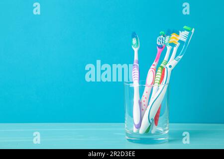 Toothbrushes in glass on a blue background. Top view Stock Photo
