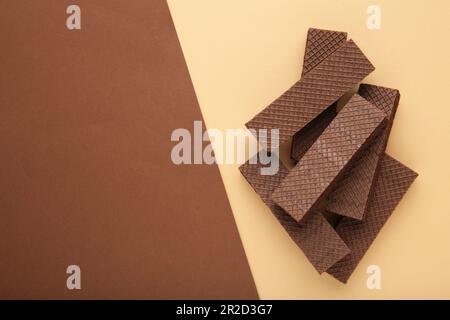 Chocolate wafers with coffee on beigeand brown background. Top view Stock Photo