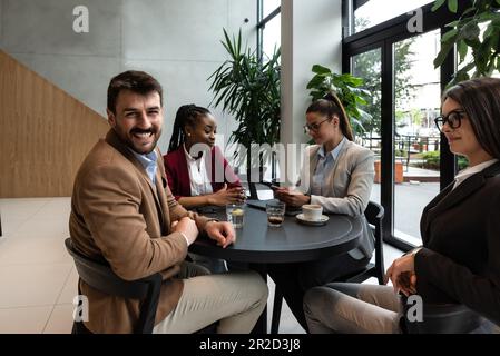 Group of young business people, managers, owners of a small company new to the labor market, staff meeting in the cafeteria, considering expanding the Stock Photo