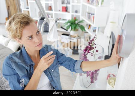 woman changing time on big wall clock Stock Photo