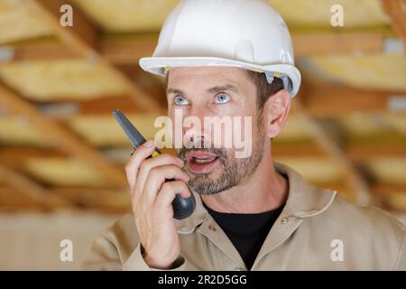 male builder in hardhat with walkie talkie Stock Photo
