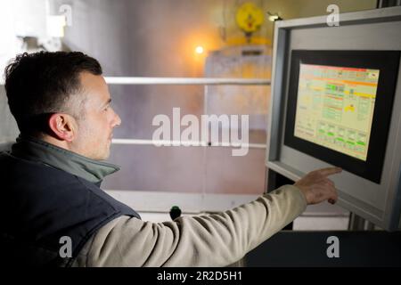 engineer operating machinery on computer touchscreen monitor Stock Photo
