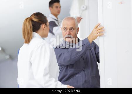 teacher explaining to female student on painting and decorating course Stock Photo