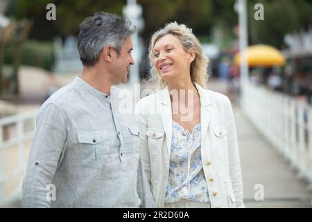 mature couple walking outdoors and looking lovingly at each other Stock Photo