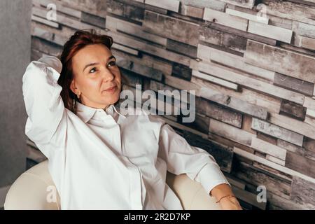 Distracted from work worried young woman sitting on couch Stock Photo