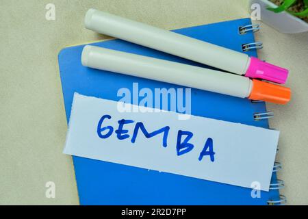 Concept of Gemba write on sticky notes isolated on Wooden Table. Stock Photo