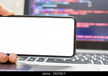 The developer wants to run an app on the smartphone device after coding from the IDE, the hand holding smartphone device the white screen, Take a clos Stock Photo