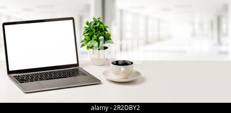 The Concept for business, technology, internet, design, programmer.  Blank white screen laptop, coffee cup, and vase are placed on a white desk in off Stock Photo