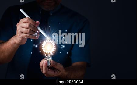 Businessman holding illuminated light bulb. Inspiration of ideas for sustainable business development, an Idea of innovation and inspiration concept, Stock Photo