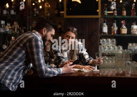 Two Diverse Entrepreneurs Have a Team Meeting in Their Stylish Coffee Shop. Barista and Cafe Owner Discuss Work Schedule and Menu on Mobile or Compute Stock Photo