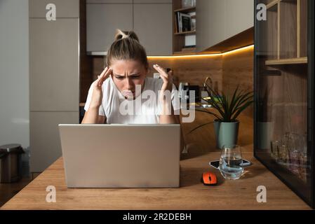 Young stressed hurt sad and shocked woman feeling betrayed finding out boyfriend husband is cheating on her by reading his messages and emails on lapt Stock Photo