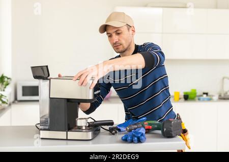 professional young worker fixing coffee machine Stock Photo