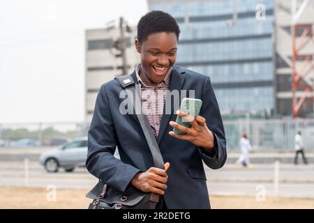 young african man checks phone and looks surprised Stock Photo