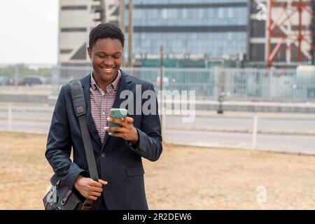 young african man going to work using phone and smiling Stock Photo