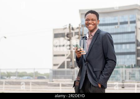 young african businessman smiling while using phone Stock Photo