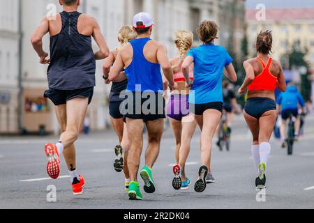 mixed group runners athletes running marathon in city, male and female joggers summer sports race Stock Photo