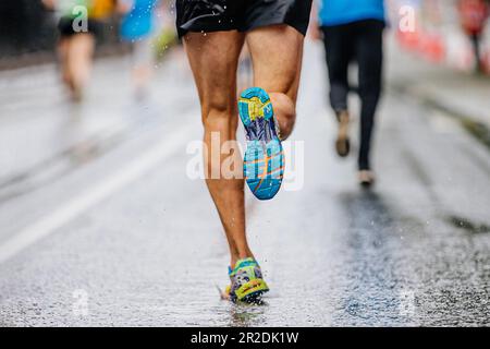 male runner irunning on water road in city marathon race, shoes