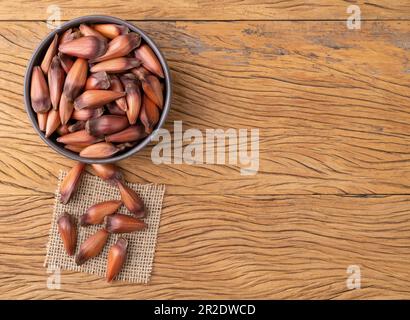 Pinions or pine tree seeds on a bowl over wooden table with copy space. Stock Photo