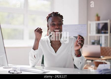 Holding Paycheck Or Payroll Check Or Insurance Cheque In Hand Stock Photo