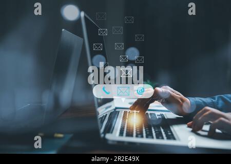 Customer support hotline contact us people connection concept. Web page online customer service technology idea. Businesswoman using computer with ema Stock Photo
