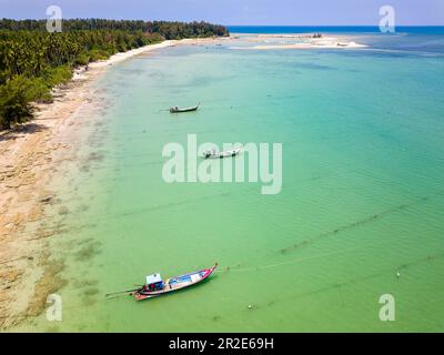 Drone view of longtail boats moored off a tropical sandy beach in Khao Lak, Thailand Stock Photo