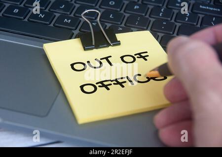 Out of office notification text sticky notes with laptop background. Out of Office concept Stock Photo