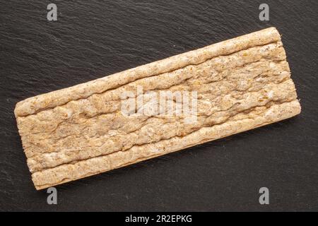 One rye crusty bread on slate stone, macro, top view. Stock Photo