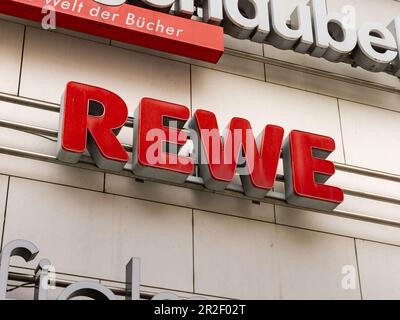 Rewe logo of the supermarket on a building facade. German grocery store and retailer. Sign as advertisement on an exterior. Stock Photo