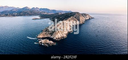 Motorboat under the lighthouse of the La Revellata peninsula, Calvi, Corsica, France. Stock Photo