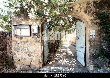 Gate entrance in the mountain village of Pigna near Calvi, Corsica, France Stock Photo