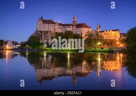 Sigmaringen Castle, illuminated, reflected in the Danube, swan in the foreground, Sigmaringen, Danube Cycle Path, Baden-Württemberg, Germany Stock Photo