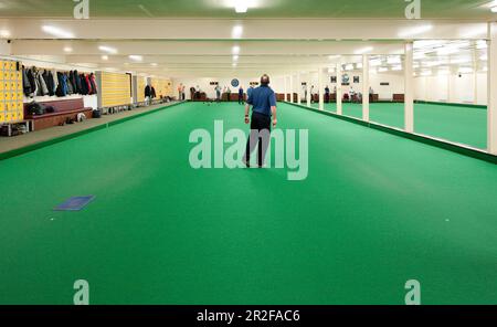 Men bowling on the Ayr Indoor lawn bowling Green in Scotland Stock Photo